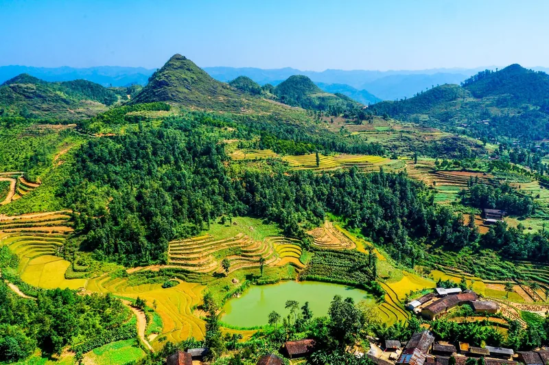 Những ruộng bậc thang và một ao nước xanh trải rộng giữa vùng núi Hà Giang, Việt Nam.